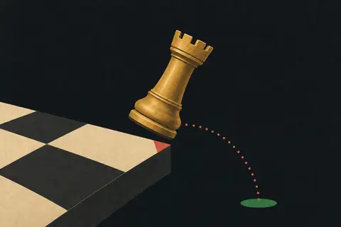 A brass rook toppling off the edge of a chessboard